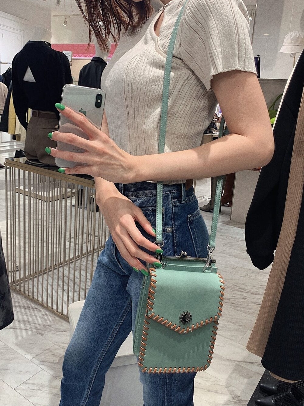 ホワイト系のニット/セーター、ブラック系のブーツ、ブルー系のデニムパンツを着用したレディースの冬コーディネートの5枚目の写真