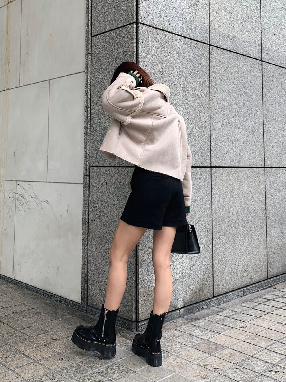 ブラック系のブーツ、ブラック系のその他パンツ、グリーン系のニット/セーターを着用したレディースの秋コーディネートの2枚目の写真