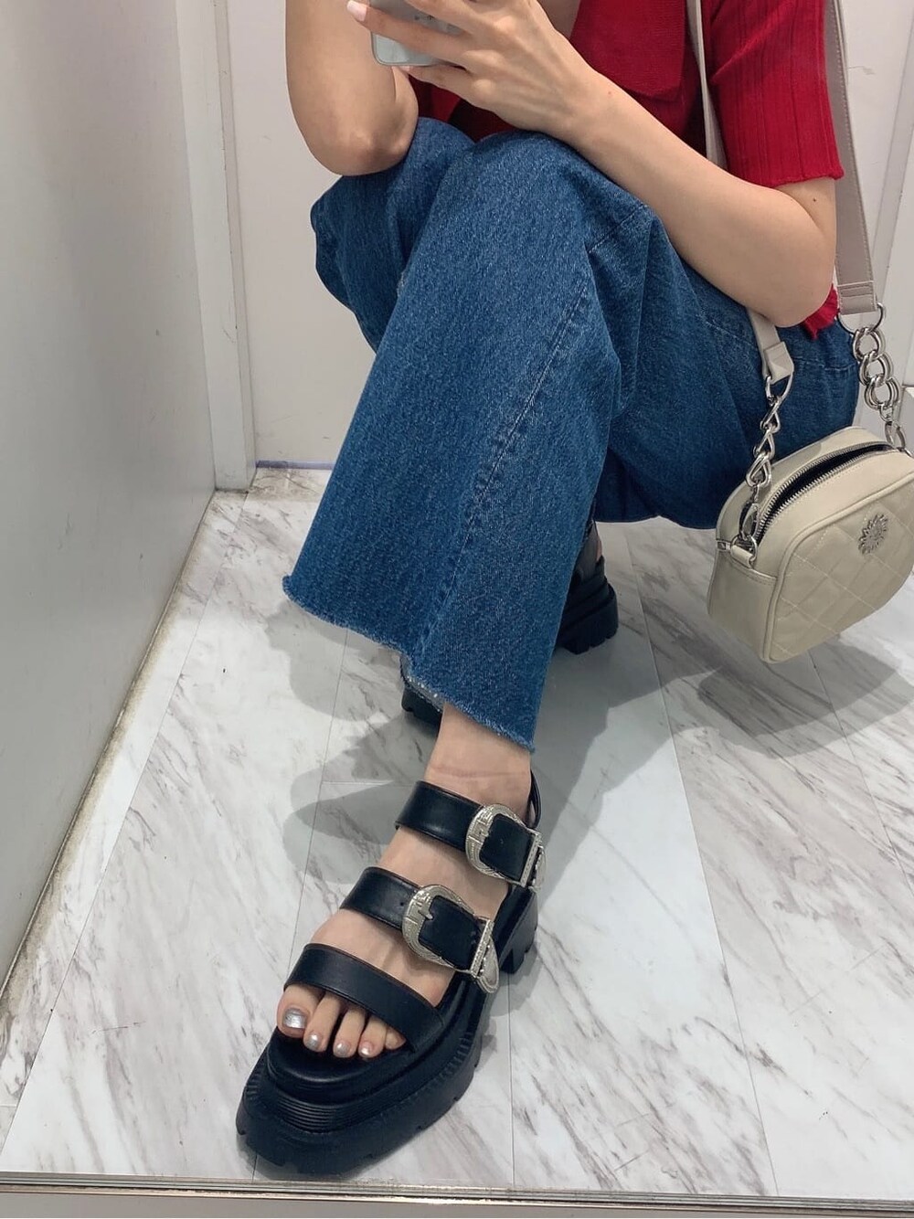 ブルー系のデニムパンツ、ホワイト系のショルダーバッグ、レッド系のニット/セーターを着用したレディースの夏コーディネートの8枚目の写真