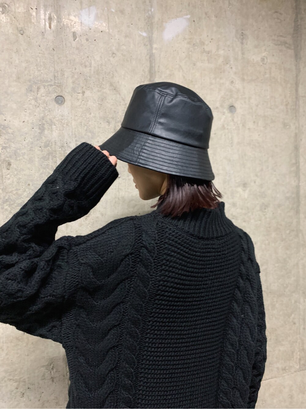 ブラウン系のショルダーバッグ、ブラック系のハットを着用したレディースの冬コーディネートの5枚目の写真