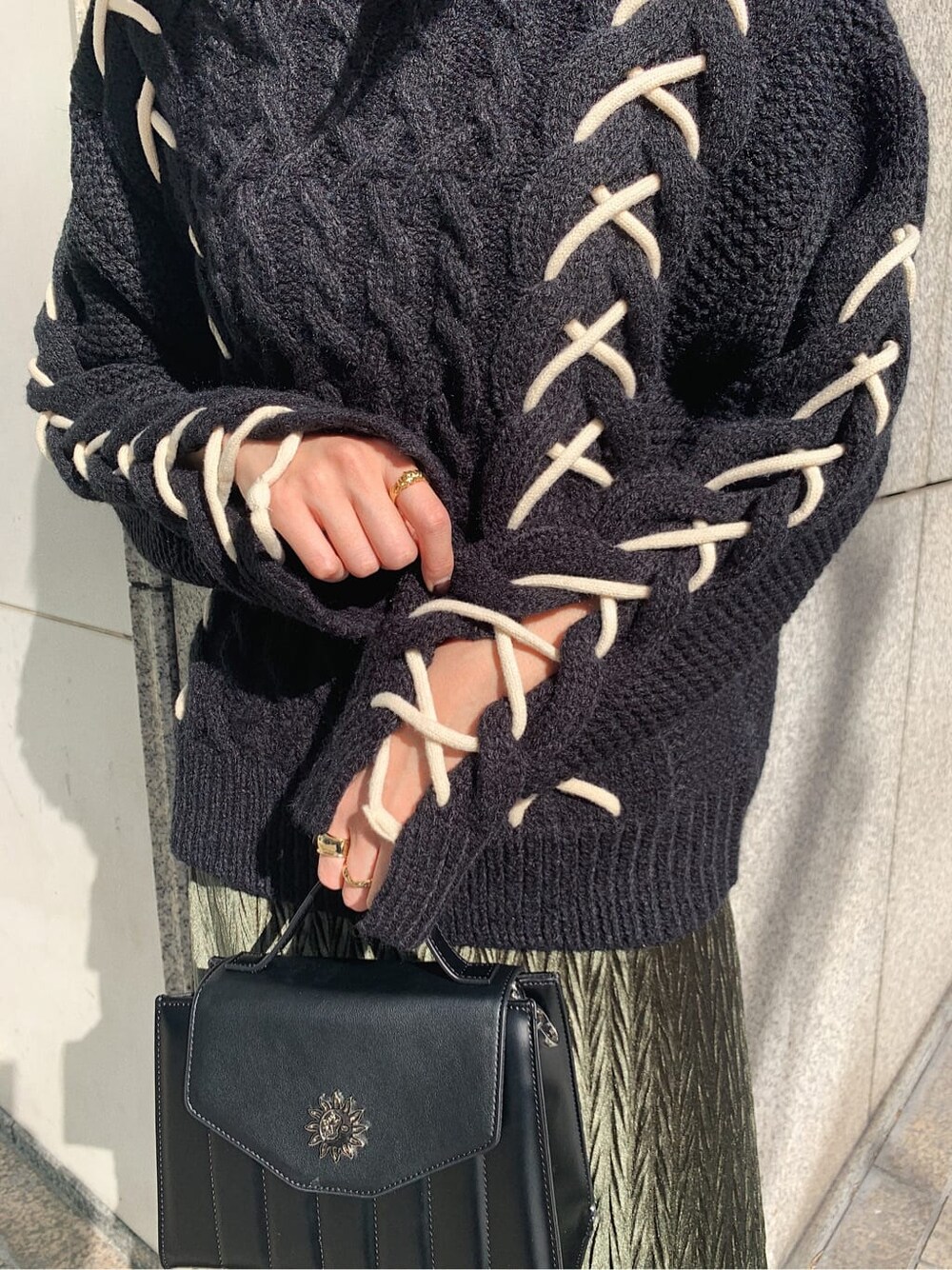 ブラック系のニット/セーター、ブラック系のショルダーバッグ、ベージュ系のワンピースを着用したレディースの冬コーディネートの4枚目の写真