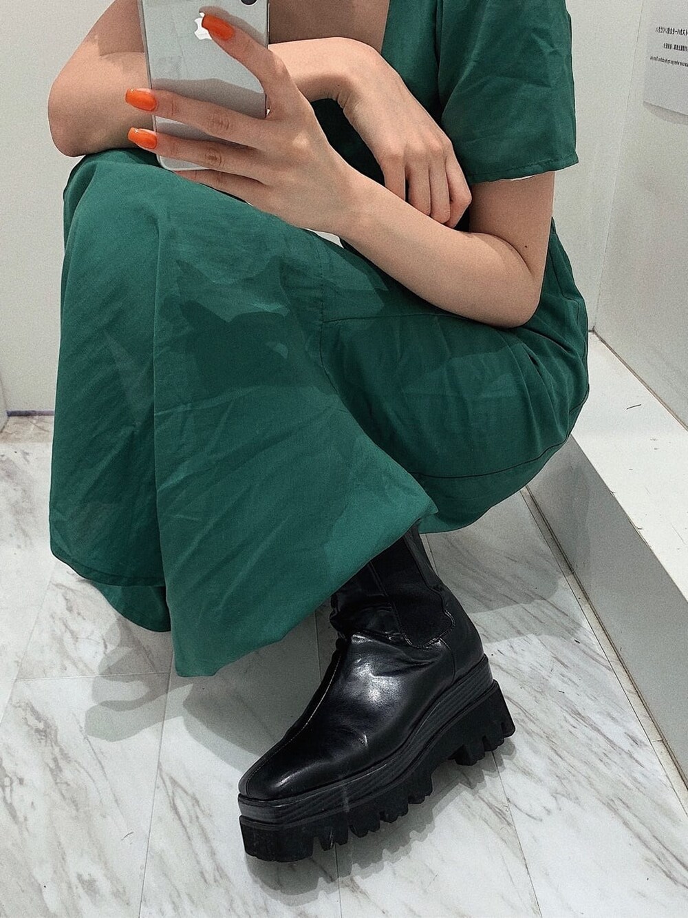 ブラック系のブーツ、ブラック系のショルダーバッグ、グリーン系のワンピースを着用したレディースの春コーディネートの9枚目の写真