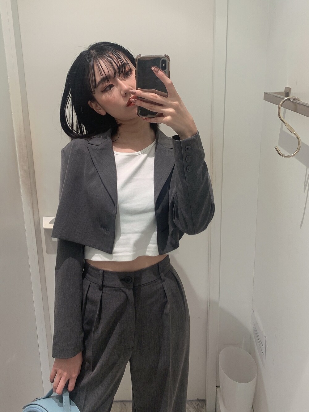 グレー系のその他パンツ、グレー系のテーラードジャケット、ブルー系のショルダーバッグを着用したレディースの春コーディネートの5枚目の写真