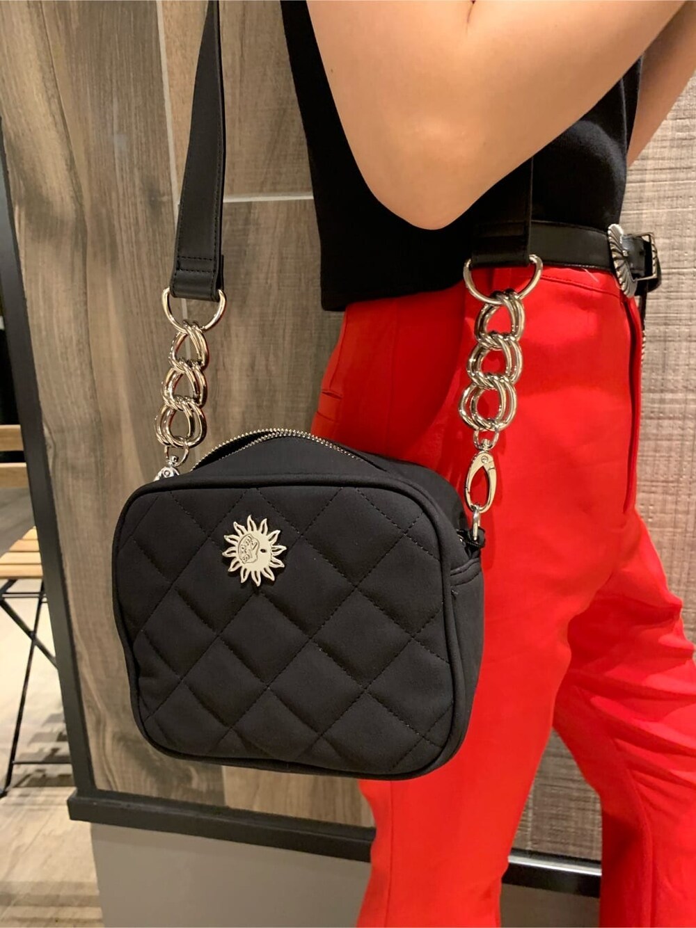 レッド系のその他パンツ、ブラック系のショルダーバッグ、ブラック系のブーツを着用したレディースの夏コーディネートの7枚目の写真