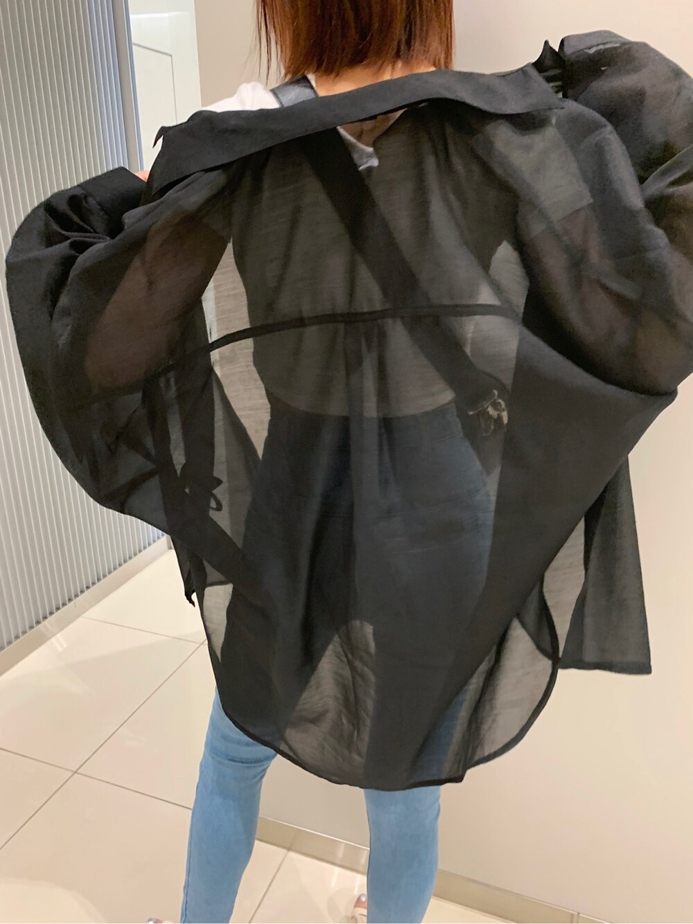 ブルー系のデニムパンツ、ブラック系のシャツ/ブラウス、ホワイト系のTシャツ/カットソーを着用したレディースの春コーディネートの5枚目の写真