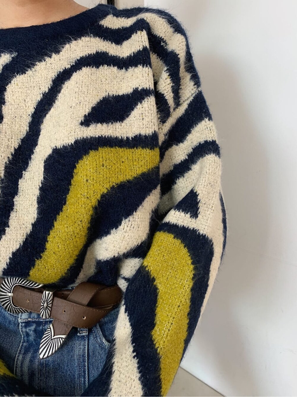 ブルー系のデニムパンツ、ブラウン系のベルトを着用したレディースの秋コーディネートの3枚目の写真