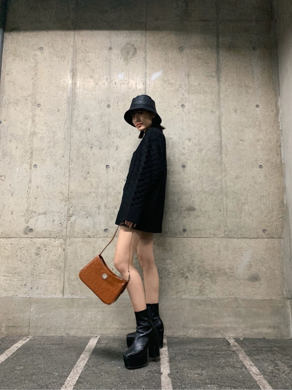 ブラウン系のショルダーバッグ、ブラック系のハットを着用したレディースの冬コーディネートの4枚目の写真