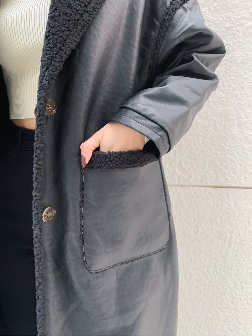ブラック系のデニムパンツ、ブラック系のショルダーバッグ、ブラック系のブーツを着用したレディースの冬コーディネートの5枚目の写真