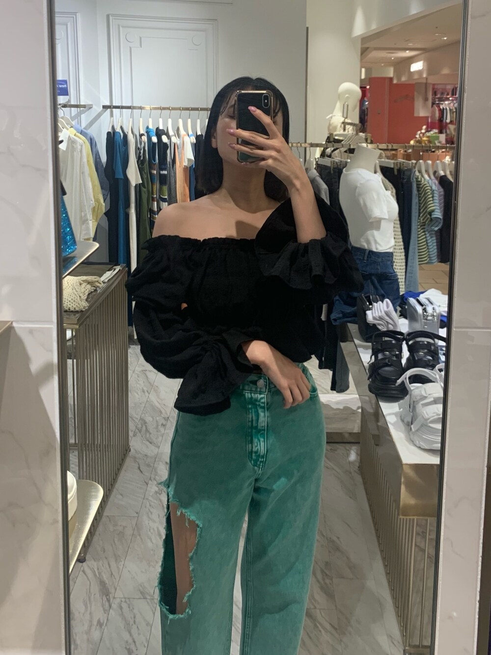 グリーン系のデニムパンツ、ブラック系のサンダル、ブラック系のシャツ/ブラウスを着用したレディースの春コーディネートの3枚目の写真