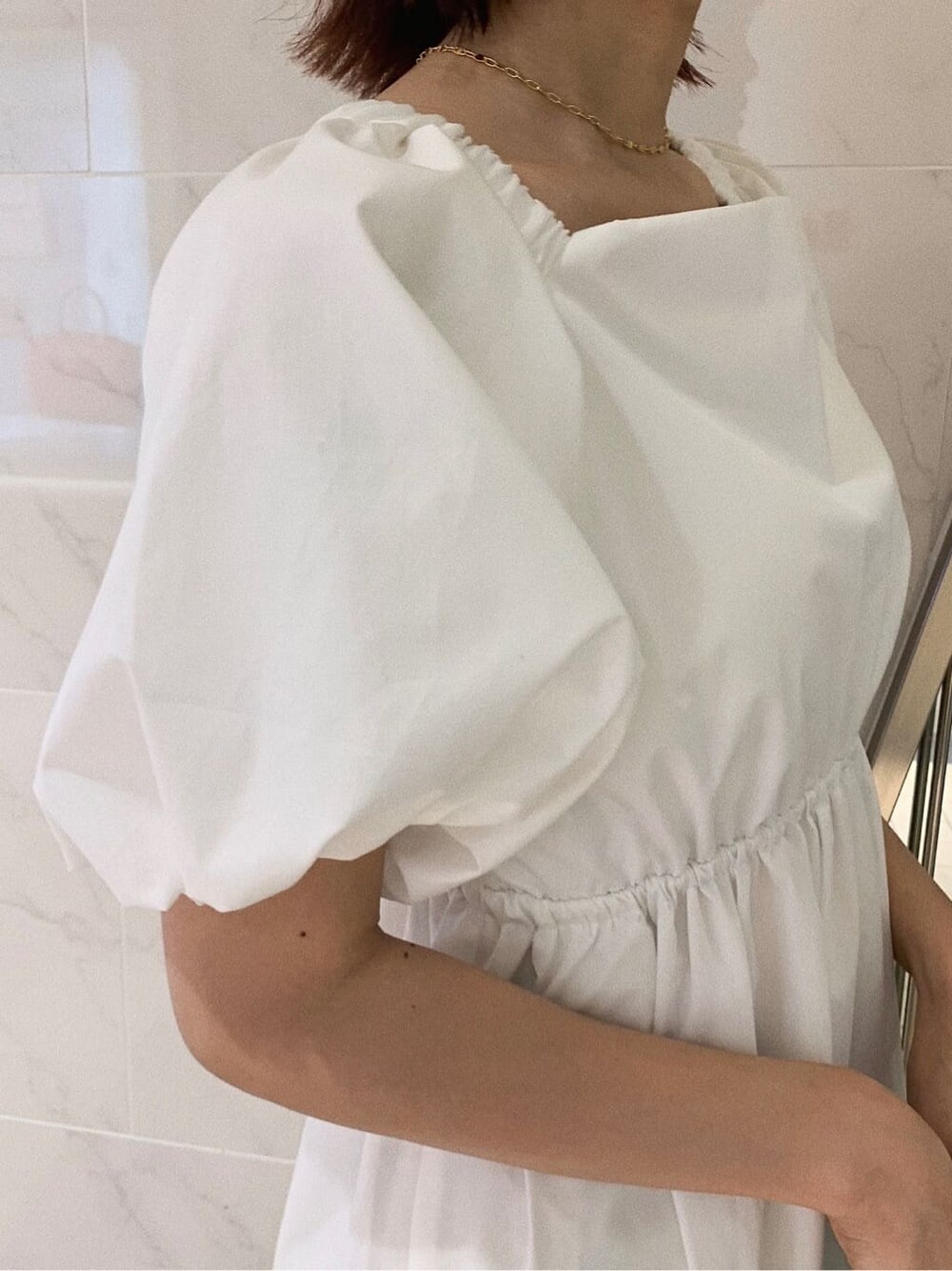 ホワイト系のワンピース、ブラック系のショルダーバッグ、その他のサンダルを着用したレディースの春コーディネートの5枚目の写真