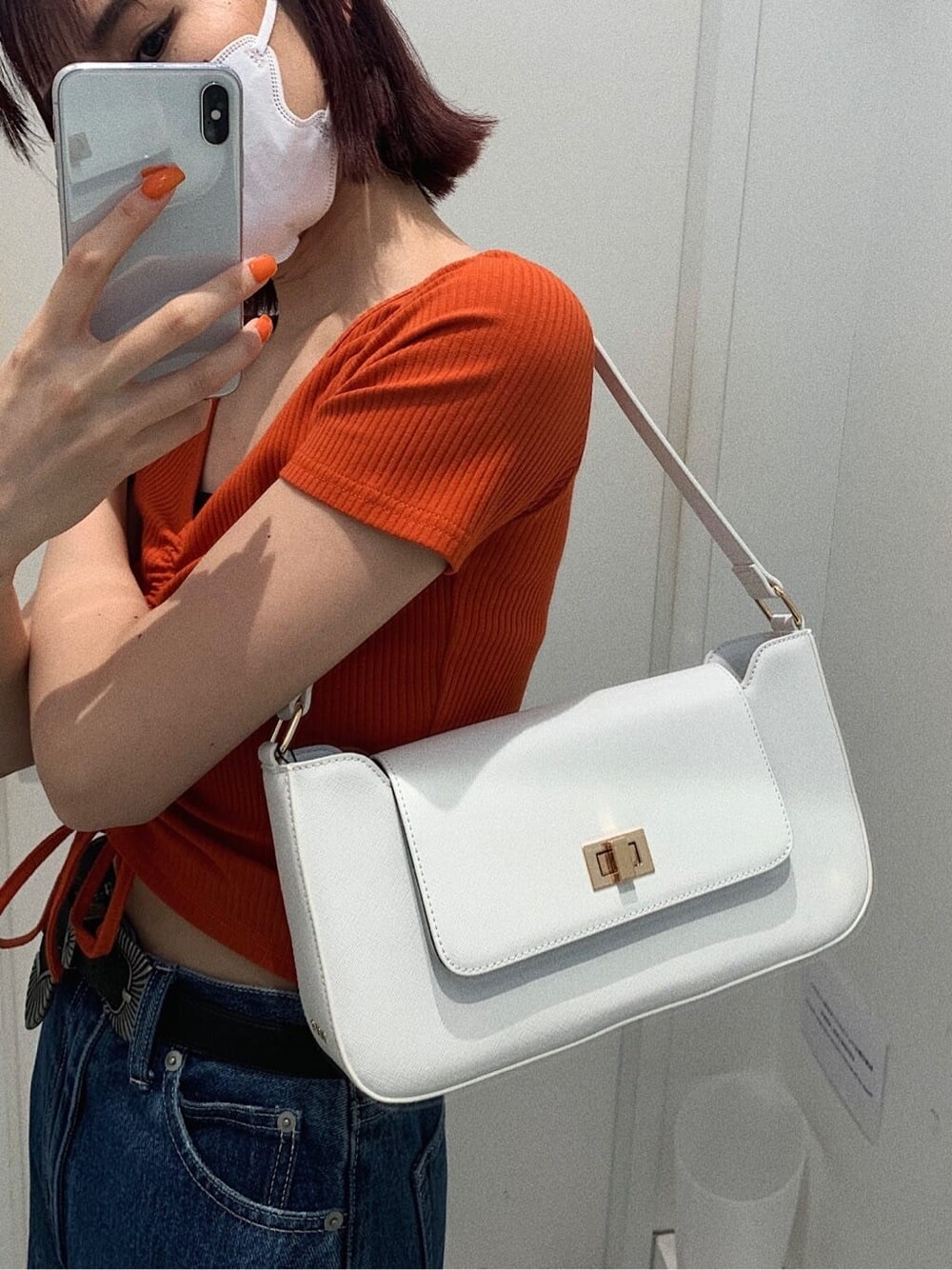 ブラック系のサンダル、ブルー系のデニムパンツ、ホワイト系のショルダーバッグを着用したレディースの春コーディネートの7枚目の写真