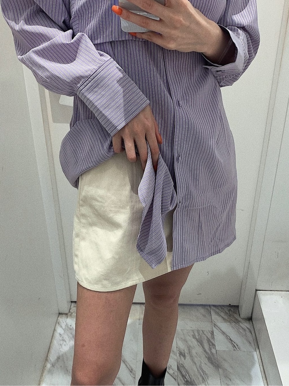 ホワイト系のスカート、ブラック系のブーツ、ホワイト系のショルダーバッグを着用したレディースの春コーディネートの6枚目の写真