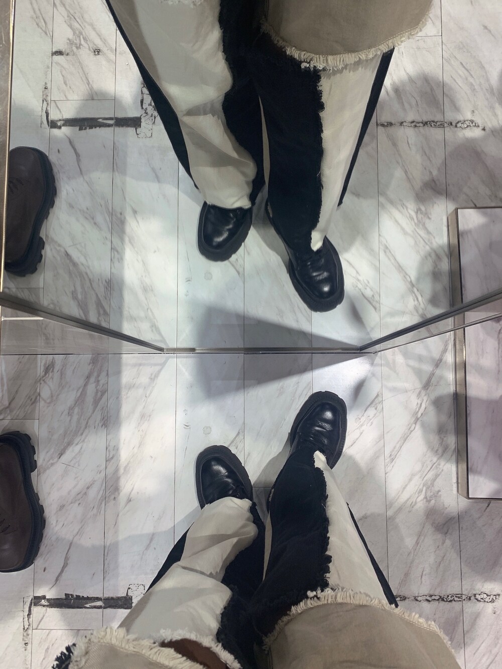 ブラック系のデニムパンツ、ブラック系のニット/セーター、ブラック系のブーツを着用したレディースの冬コーディネートの8枚目の写真