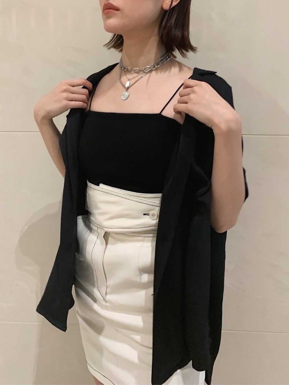 ホワイト系のスカート、ブラック系のサンダル、ブラック系のシャツ/ブラウスを着用したレディースの春コーディネートの5枚目の写真