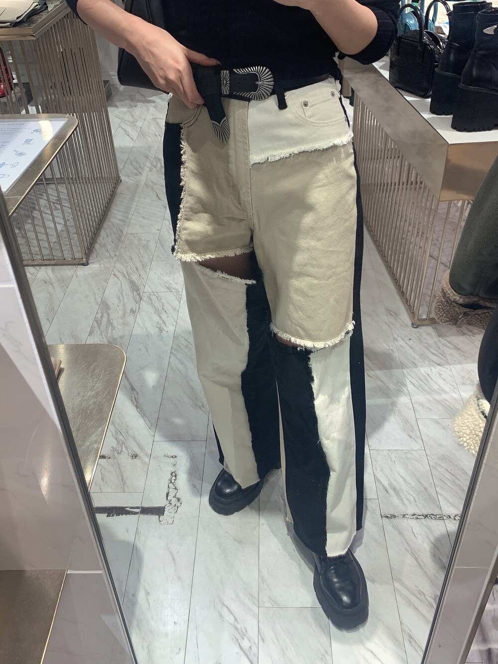 ブラック系のデニムパンツ、ブラック系のニット/セーター、ブラック系のブーツを着用したレディースの冬コーディネートの4枚目の写真
