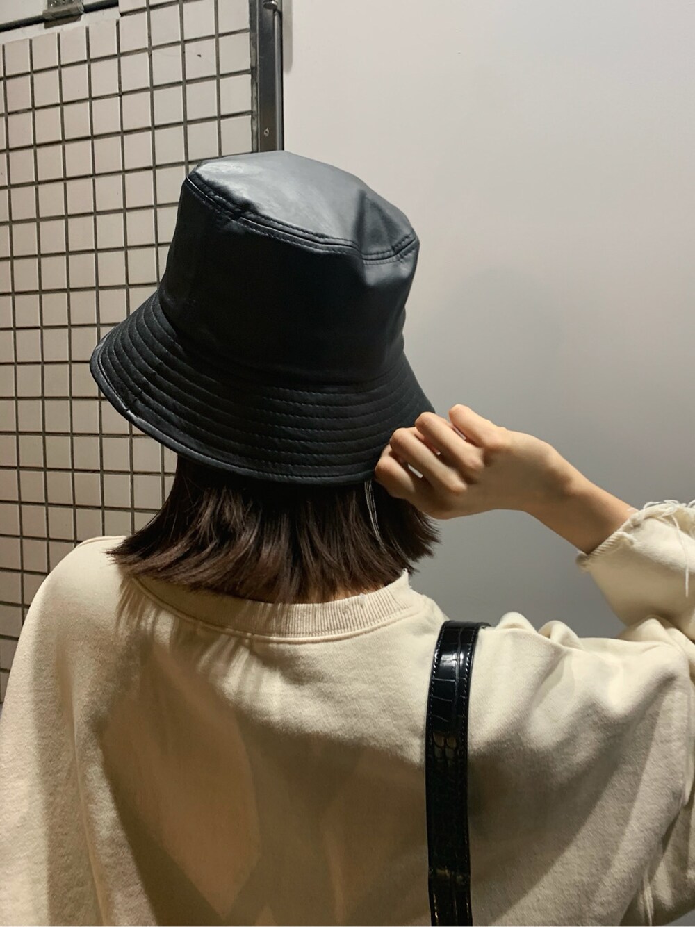 ホワイト系のスウェット、ブラック系のハット、ブラック系のベルトを着用したレディースの春コーディネートの7枚目の写真