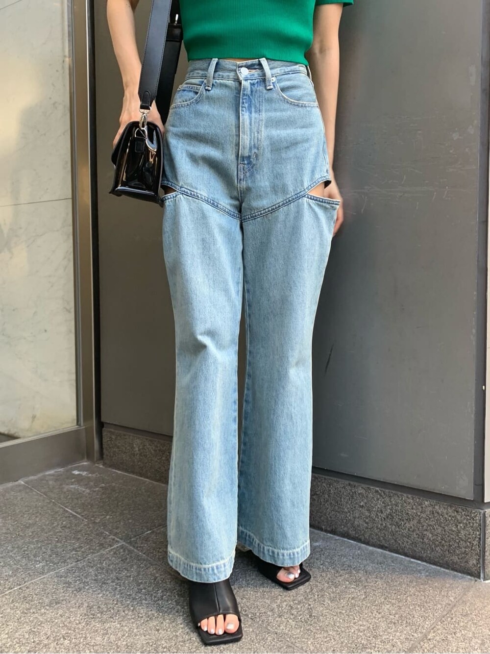 ブルー系のデニムパンツ、ブラック系のサンダル、ブラック系のショルダーバッグを着用したレディースの夏コーディネートの5枚目の写真