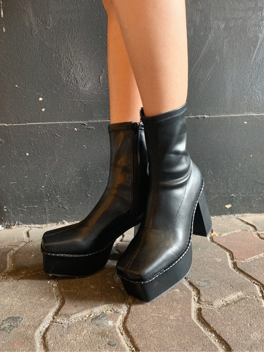 ホワイト系のブルゾン、ブラック系のブーツ、ゴールド系のリングを着用したレディースの冬コーディネートの6枚目の写真