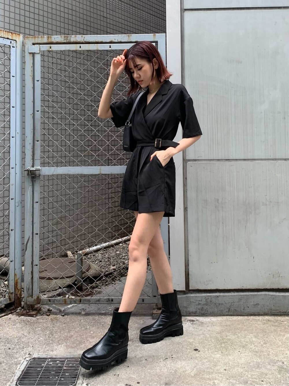 ブラック系のブーツ、ブラック系のつなぎ/オールインワン、ブラック系のショルダーバッグを着用したレディースの春コーディネートの2枚目の写真