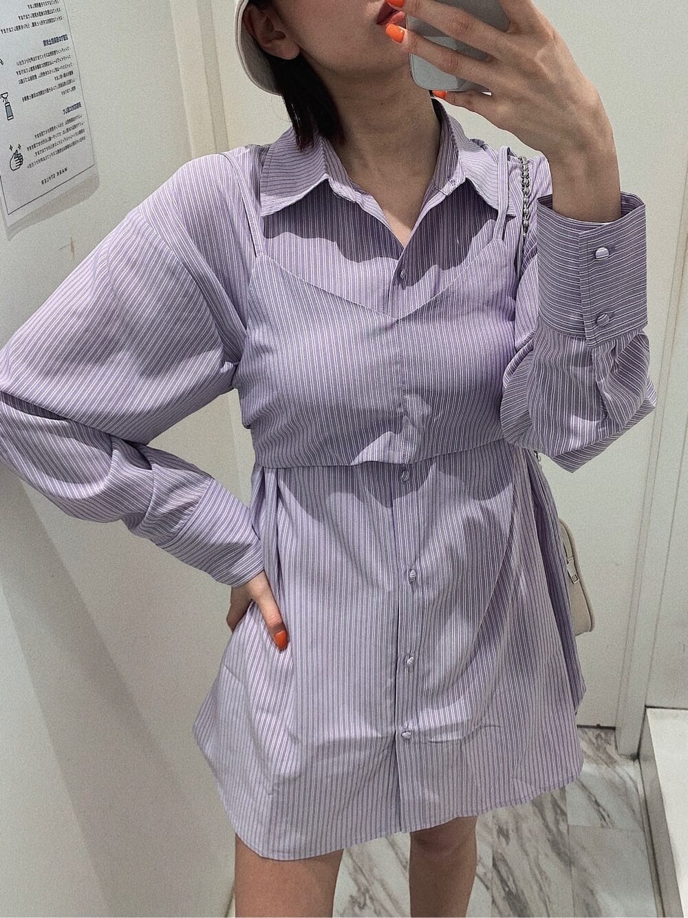 ホワイト系のスカート、ブラック系のブーツ、ホワイト系のショルダーバッグを着用したレディースの春コーディネートの2枚目の写真