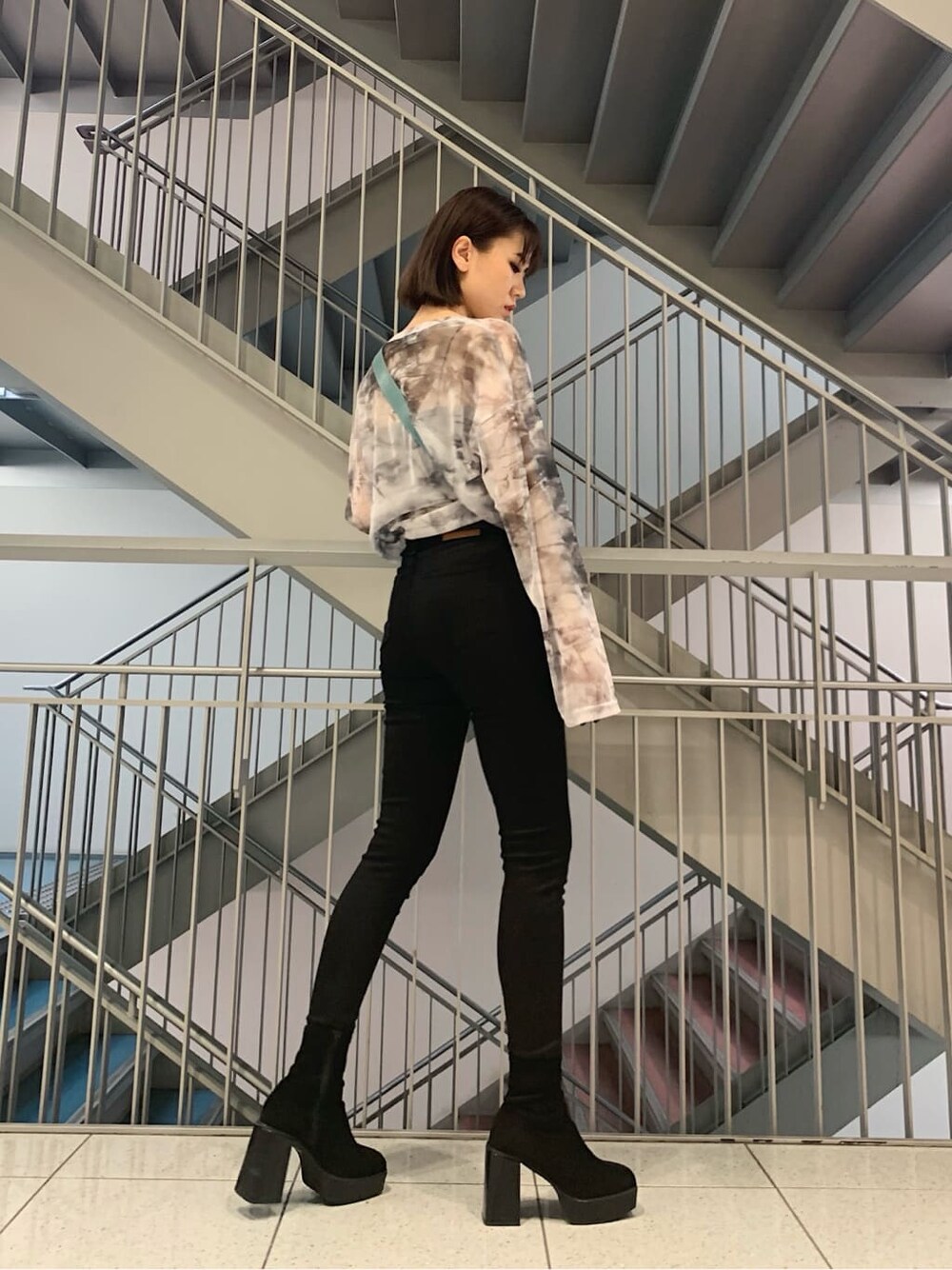 ブラック系のデニムパンツ、グレー系のTシャツ/カットソー、その他のブーツを着用したレディースの秋コーディネートの2枚目の写真