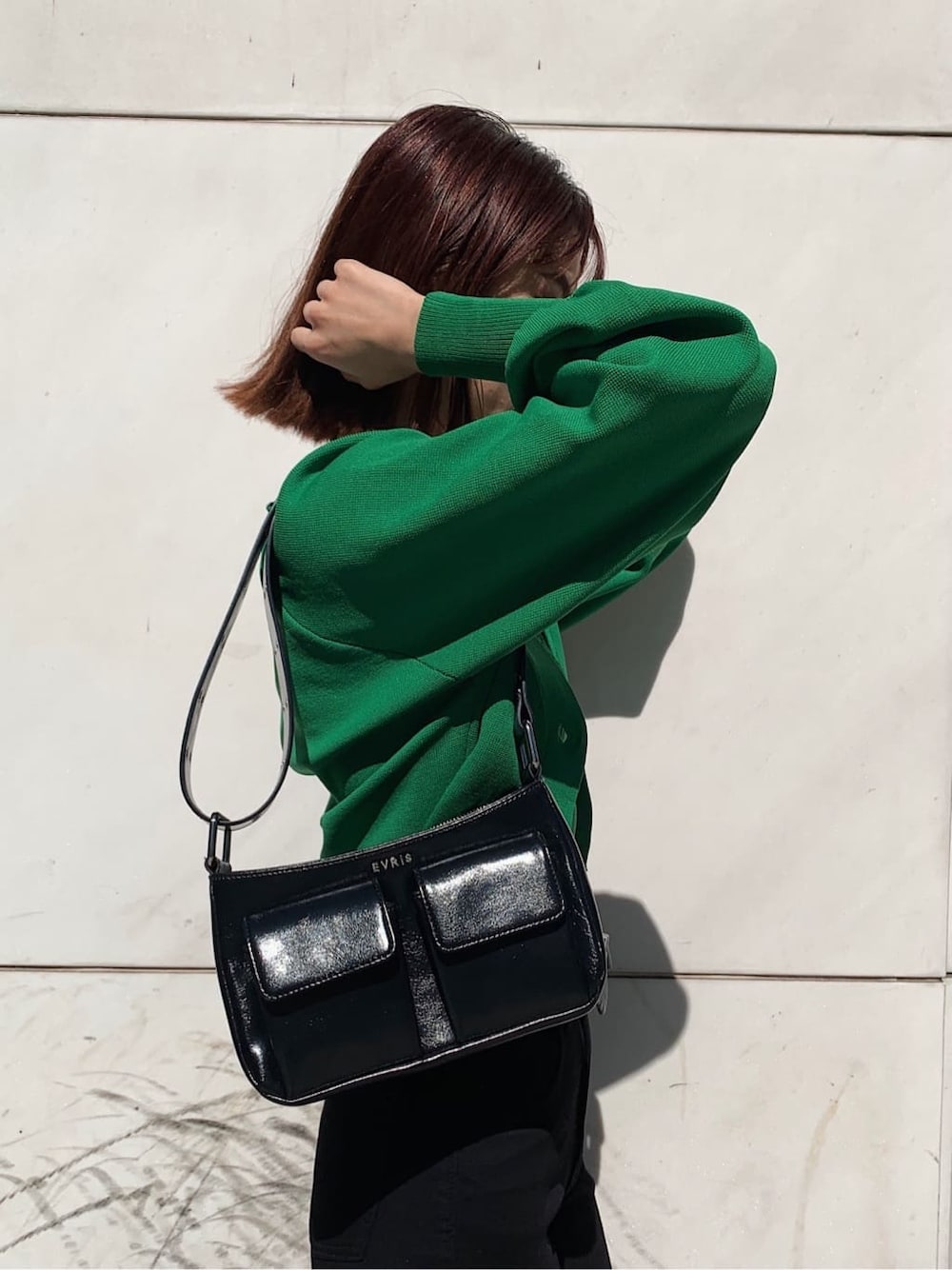 ブラック系のデニムパンツ、ブラック系のローファー、ブラック系のショルダーバッグを着用したレディースの春コーディネートの8枚目の写真