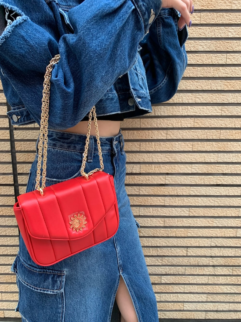 ブルー系のデニムジャケット、ブルー系のデニムスカート、レッド系のショルダーバッグを着用したレディースの秋コーディネートの7枚目の写真