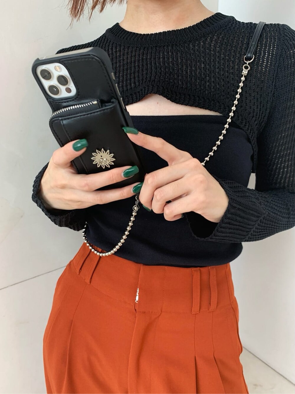 オレンジ系のその他パンツ、ブラック系のローファー、ブラック系のスマホケース/カバーを着用したレディースの秋コーディネートの5枚目の写真