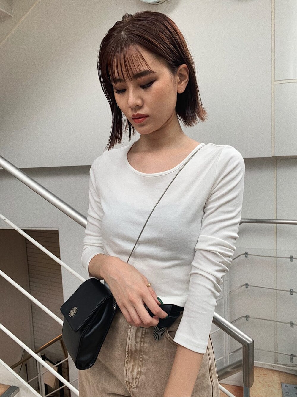 ホワイト系のTシャツ/カットソー、ベージュ系のデニムパンツ、ブラック系のベルトを着用したレディースの秋コーディネートの3枚目の写真