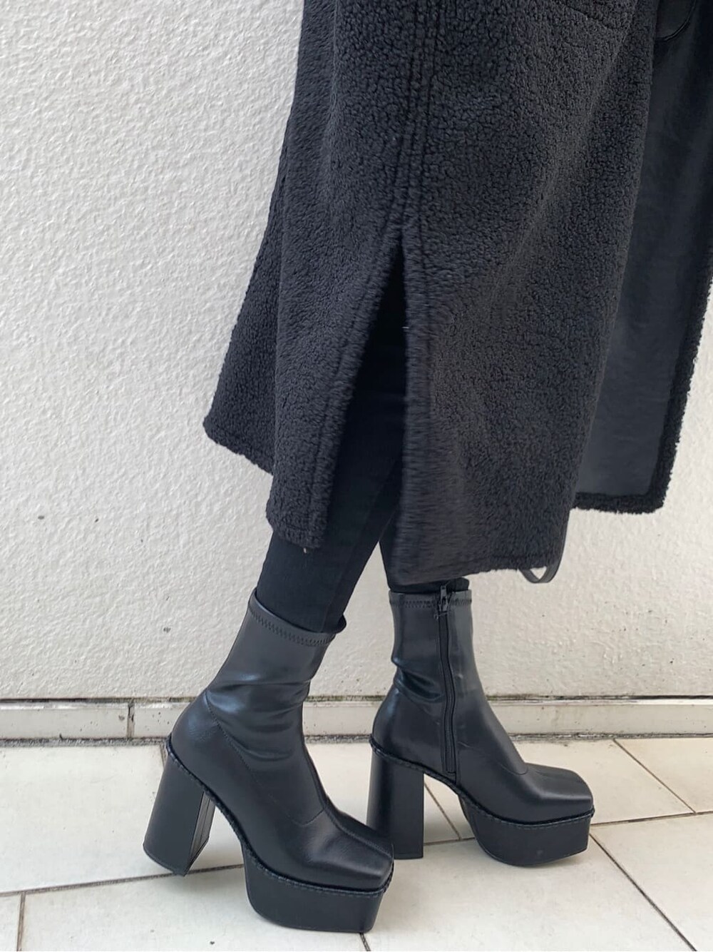 ブラック系のデニムパンツ、ブラック系のショルダーバッグ、ブラック系のブーツを着用したレディースの冬コーディネートの8枚目の写真