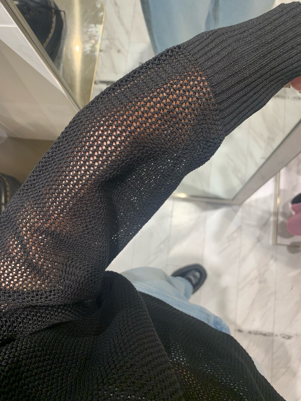 ブルー系のデニムパンツ、ブラック系のニット/セーター、ホワイト系のキャミソールを着用したレディースの春コーディネートの8枚目の写真