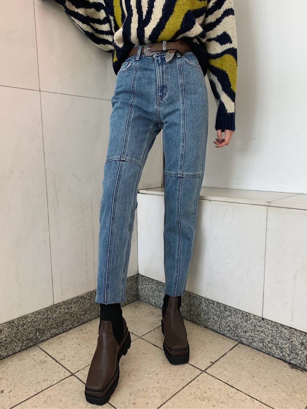 ブルー系のデニムパンツ、ブラウン系のベルトを着用したレディースの秋コーディネートの4枚目の写真