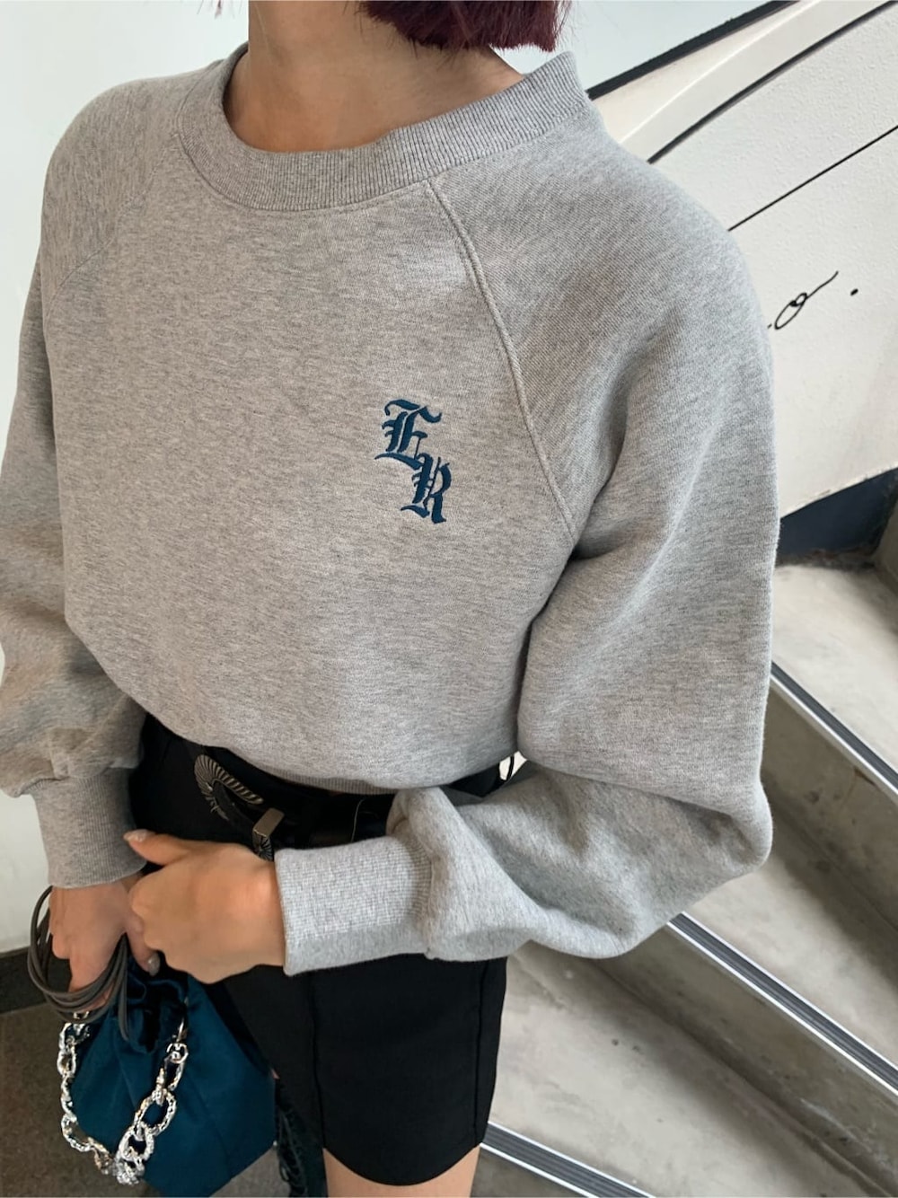 ブラック系のブーツ、ブルー系のハンドバッグ、グレー系のスウェットを着用したレディースの秋コーディネートの5枚目の写真