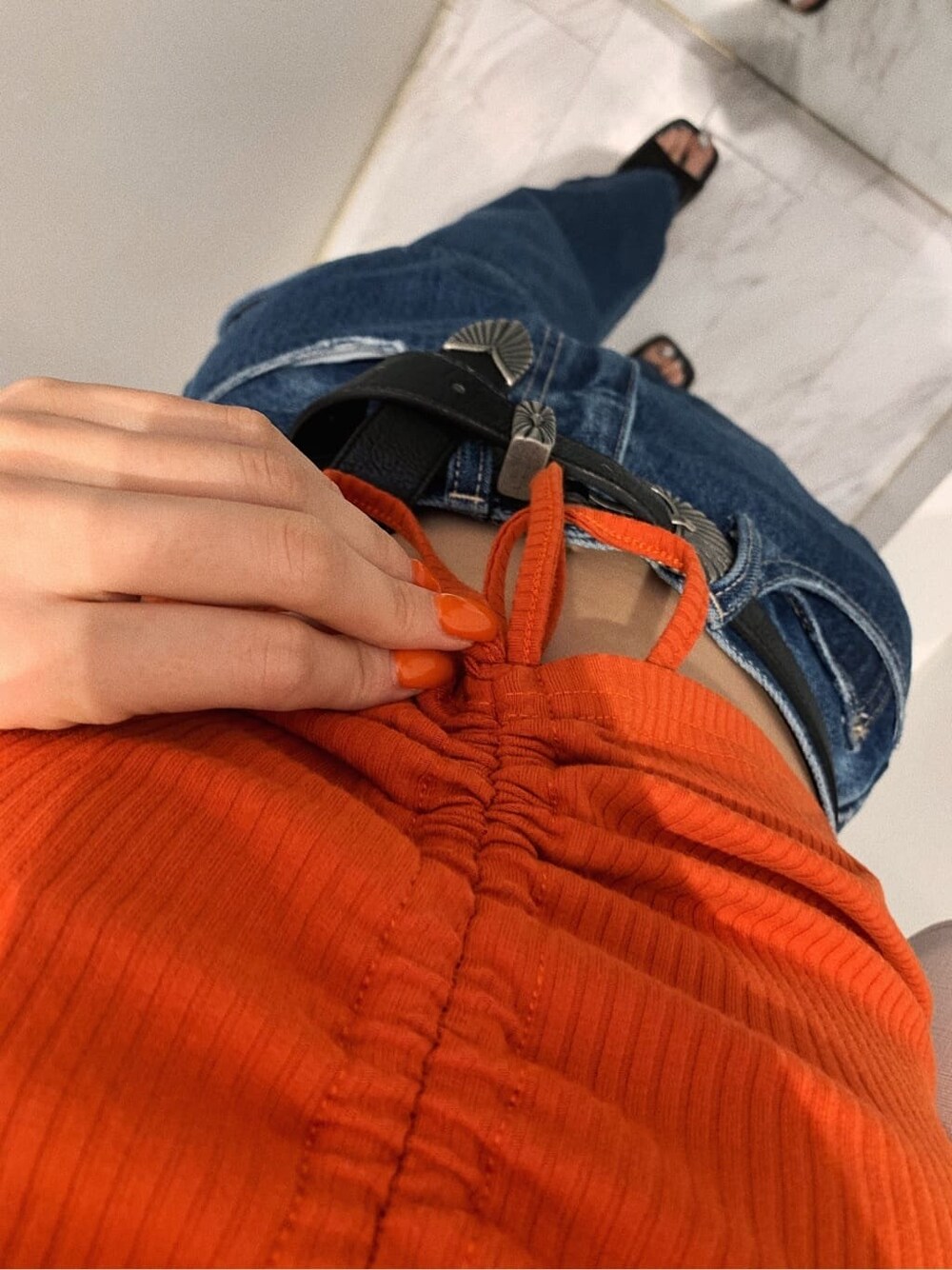 ブラック系のサンダル、ブルー系のデニムパンツ、ホワイト系のショルダーバッグを着用したレディースの春コーディネートの8枚目の写真