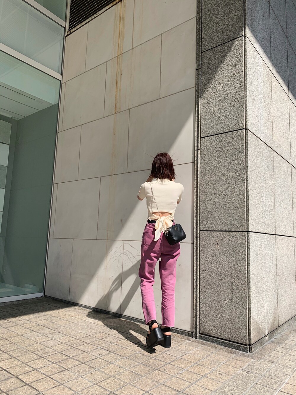 ブラック系のサンダル、パープル系のデニムパンツ、ホワイト系のTシャツ/カットソーを着用したレディースの春コーディネートの2枚目の写真