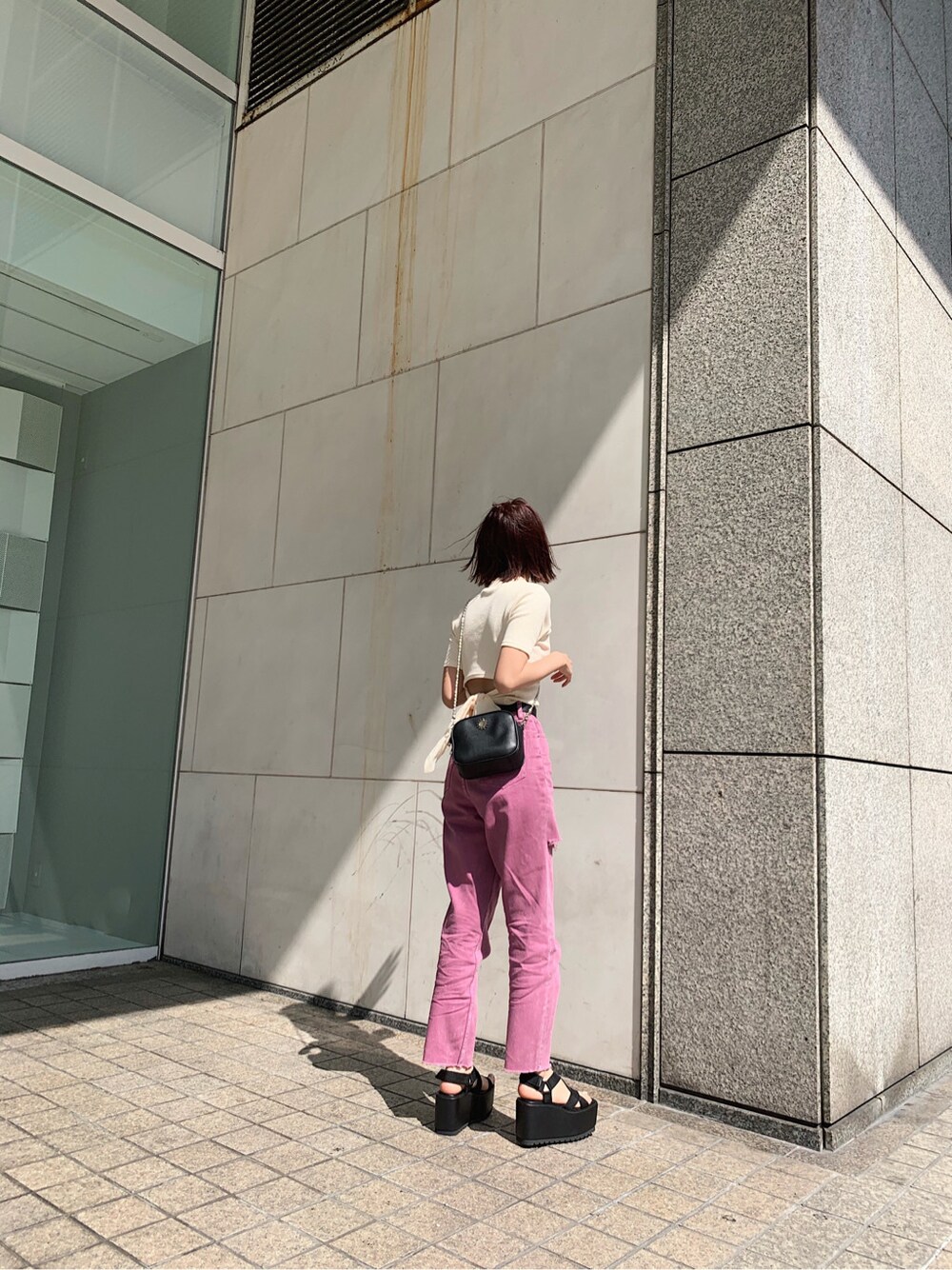 ブラック系のサンダル、パープル系のデニムパンツ、ホワイト系のTシャツ/カットソーを着用したレディースの春コーディネートの4枚目の写真