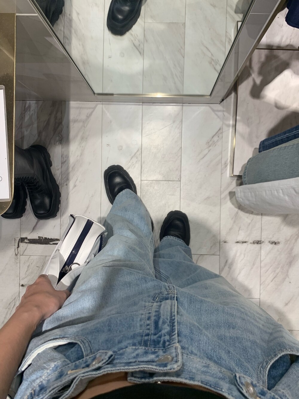 ブラック系のTシャツ/カットソー、ブルー系のデニムパンツ、ブラック系のブーツを着用したレディースの春コーディネートの7枚目の写真