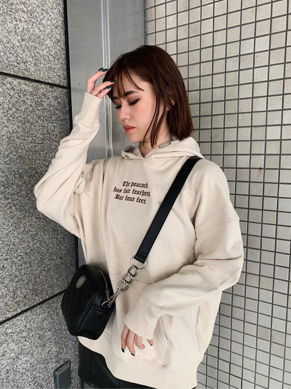 ブラック系のスカート、ブラック系のブーツ、ブラック系のショルダーバッグを着用したレディースの秋コーディネートの3枚目の写真