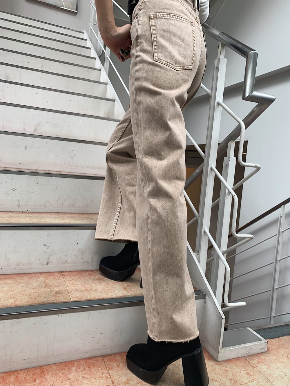 ホワイト系のTシャツ/カットソー、ベージュ系のデニムパンツ、ブラック系のベルトを着用したレディースの秋コーディネートの4枚目の写真