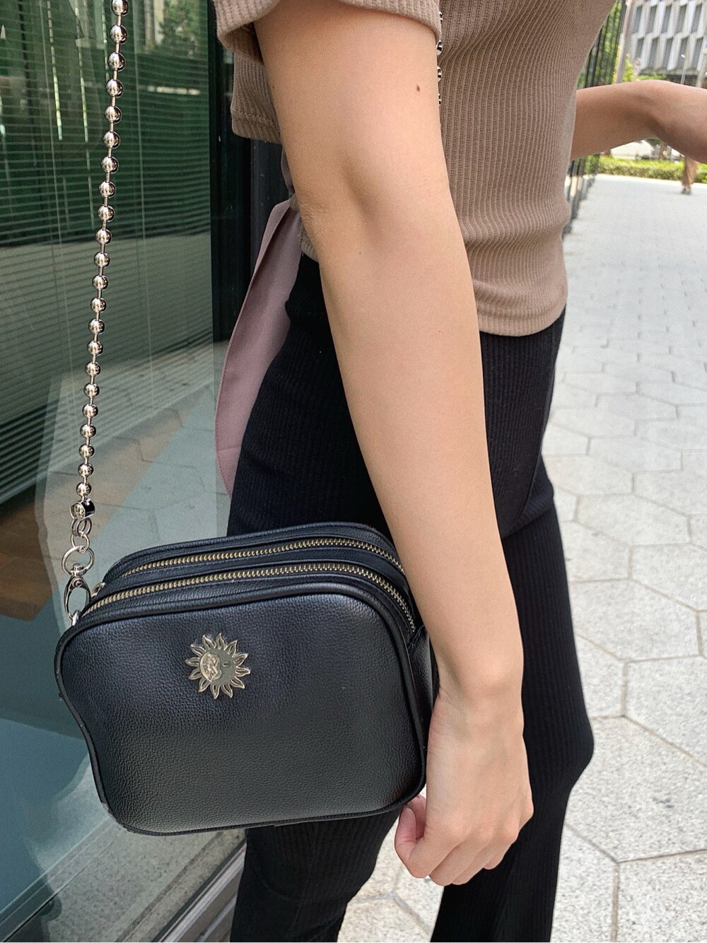 ブラック系のその他パンツ、ブラック系のサンダル、ブラウン系のTシャツ/カットソーを着用したレディースの春コーディネートの8枚目の写真