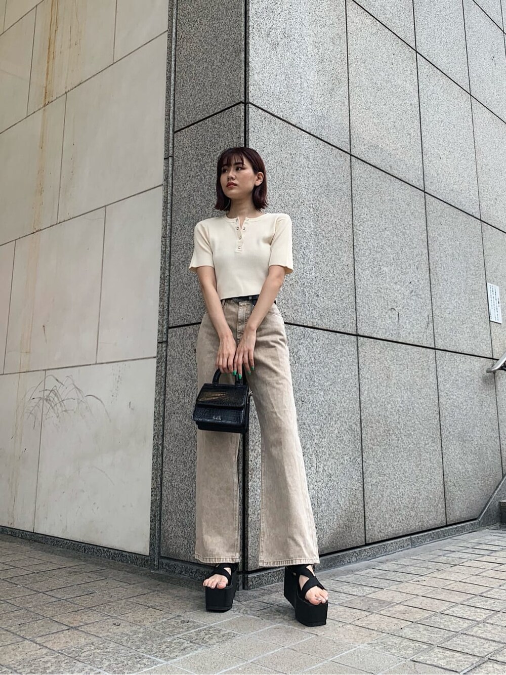 ブラック系のサンダル、ベージュ系のデニムパンツ、ホワイト系のニット/セーターを着用したレディースの夏コーディネートの2枚目の写真