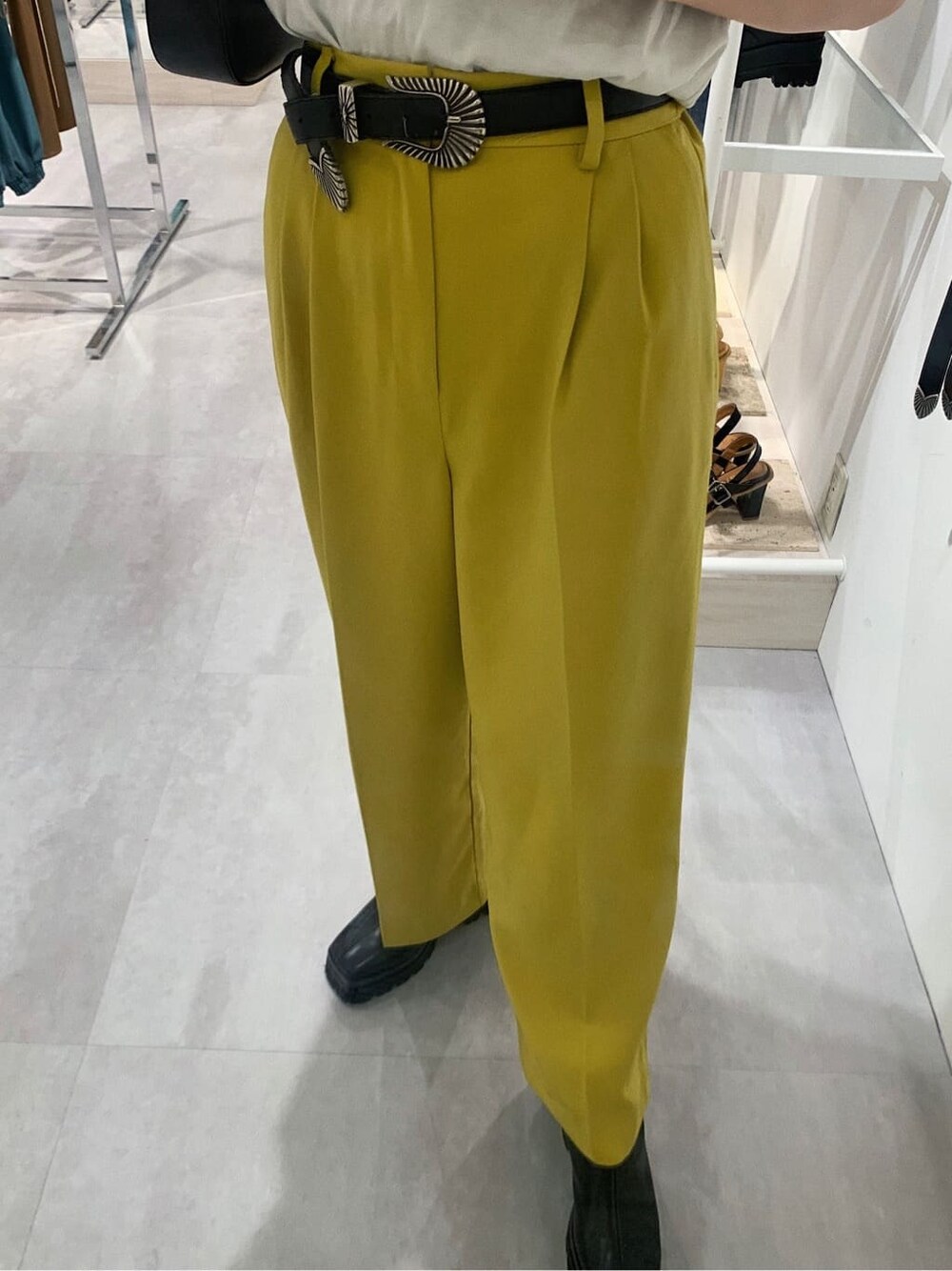 イエロー系のスラックス、ホワイト系のTシャツ/カットソー、ブラック系のブーツを着用したレディースの春コーディネートの5枚目の写真