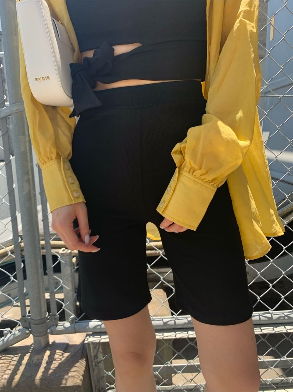 ブラック系のTシャツ/カットソー、ホワイト系のショルダーバッグ、ブラック系のその他パンツを着用したレディースの夏コーディネートの8枚目の写真