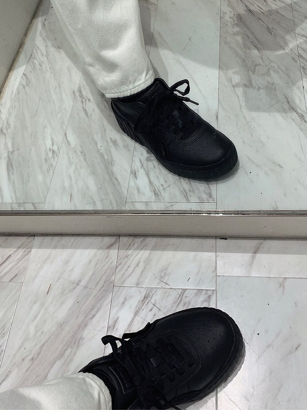 ブラック系のスニーカー、ホワイト系のショルダーバッグ、ホワイト系のデニムパンツを着用したレディースの春コーディネートの8枚目の写真