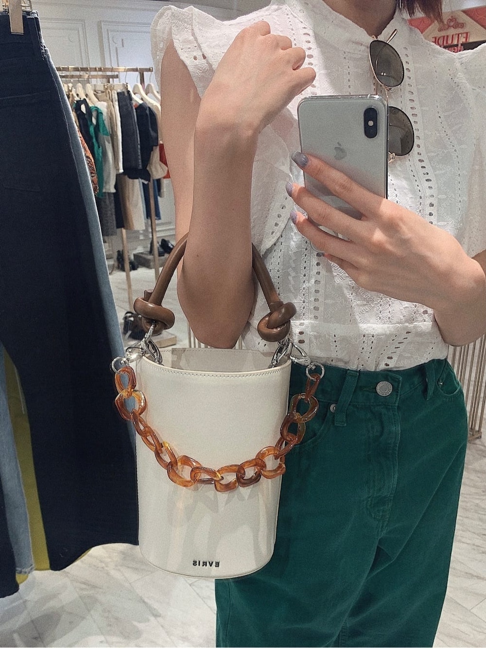 グリーン系のデニムパンツ、ホワイト系のタンクトップ、ホワイト系のサンダルを着用したレディースの春コーディネートの7枚目の写真