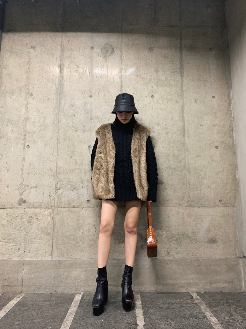 ブラウン系のショルダーバッグ、ブラック系のハットを着用したレディースの冬コーディネートの7枚目の写真
