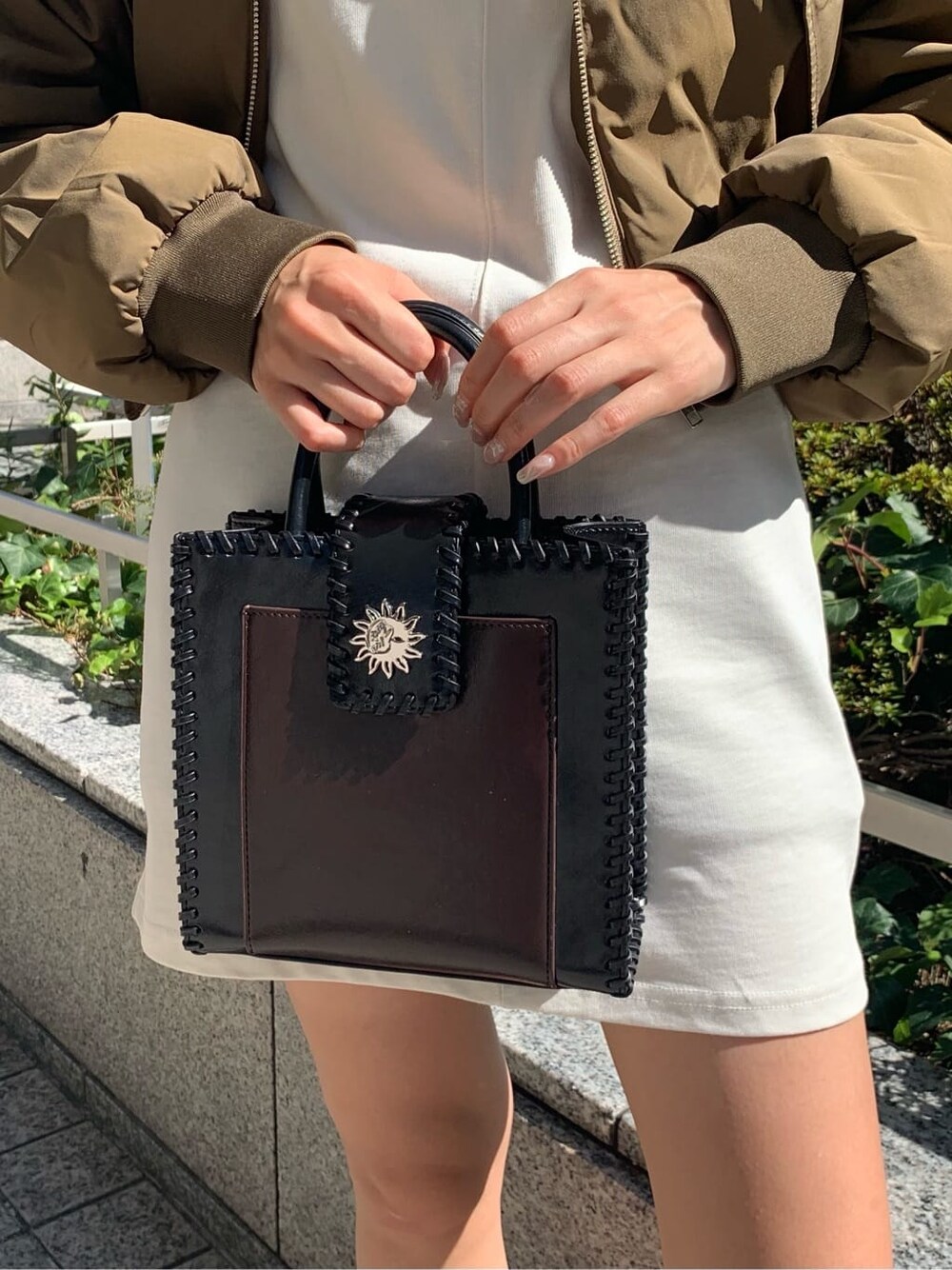 ブラック系のショルダーバッグ、グリーン系のMA-1、ホワイト系のワンピースを着用したレディースの秋コーディネートの8枚目の写真