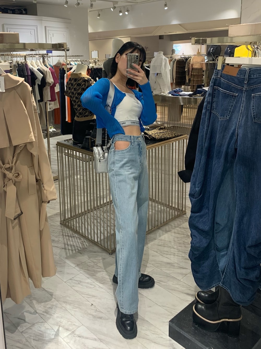 ブルー系のデニムパンツ、シルバー系のショルダーバッグ、ブルー系のカーディガン/ボレロを着用したレディースの春コーディネートの2枚目の写真