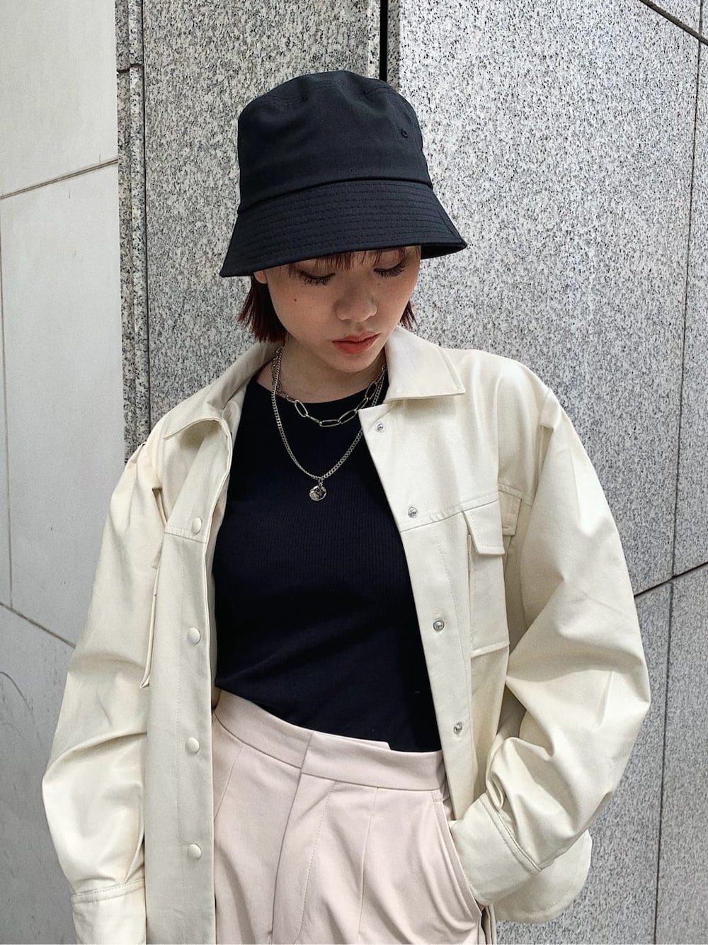 ホワイト系のテーラードジャケット、ブラック系のブーツ、ブラック系のショルダーバッグを着用したレディースの秋コーディネートの3枚目の写真