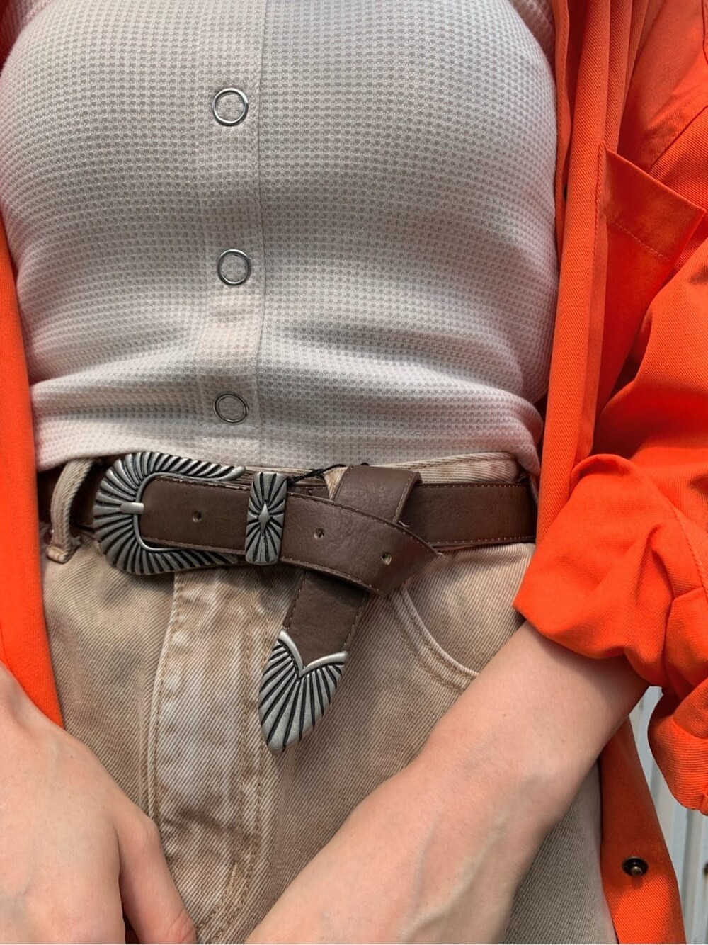 ブラック系のブーツ、ベージュ系のデニムスカート、オレンジ系のシャツ/ブラウスを着用したレディースの夏コーディネートの4枚目の写真